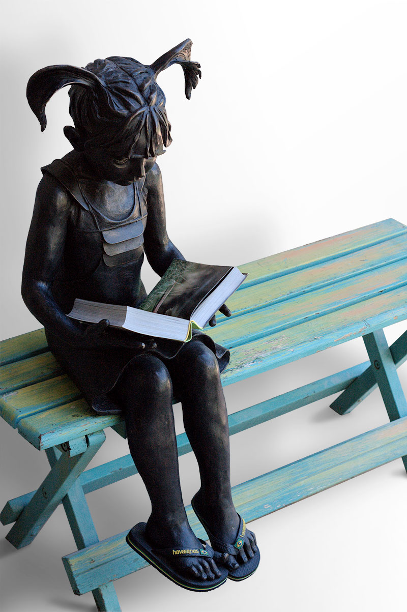 Scultura in bronzo di Lucia Zei che ritrae una bambina che legge un libro
