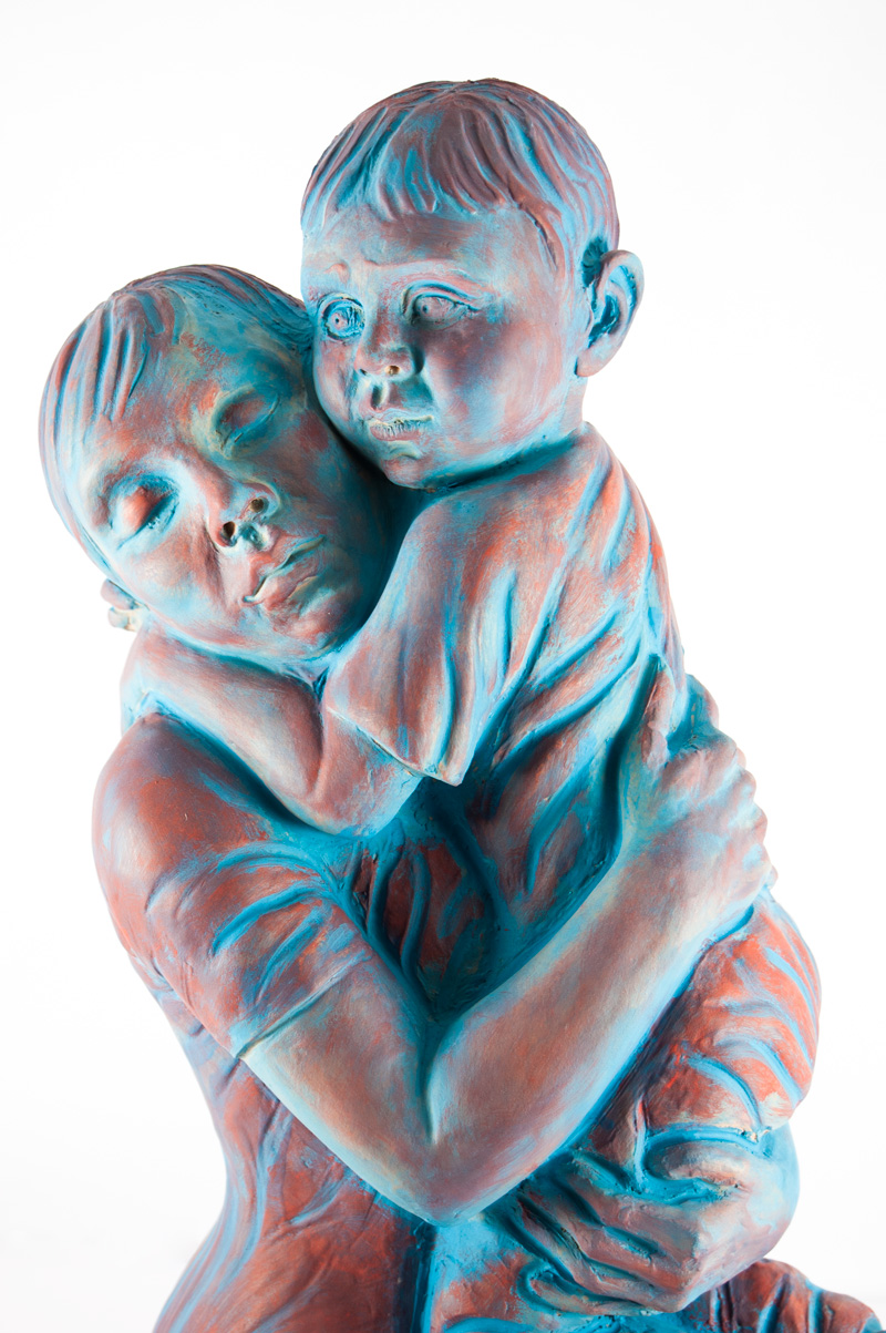 Scultura in terracotta di Lucia Zei che ritrae una donna mentre abbraccia un bambino