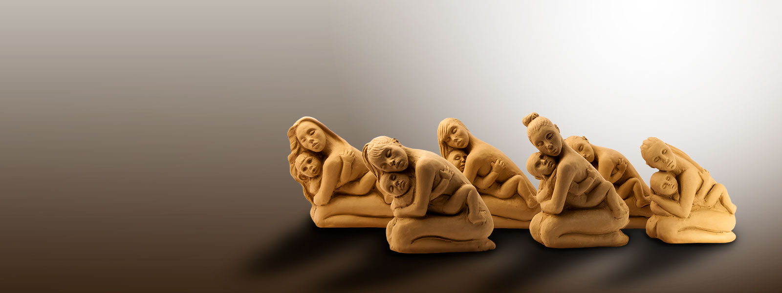 6 sculture in terracotta di Lucia Zei che ritraggono altrettante mamme che abbracciano il proprio bambino